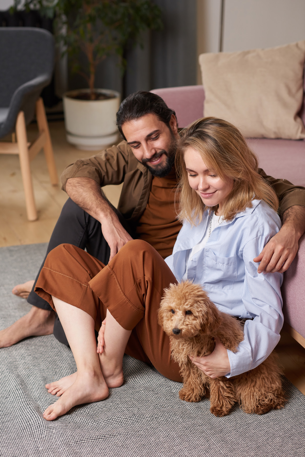 man and woman sitting on floor next to their dog