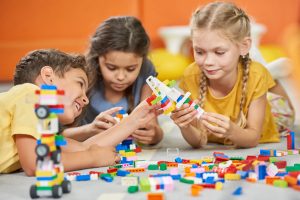 three kids playing with building blocks