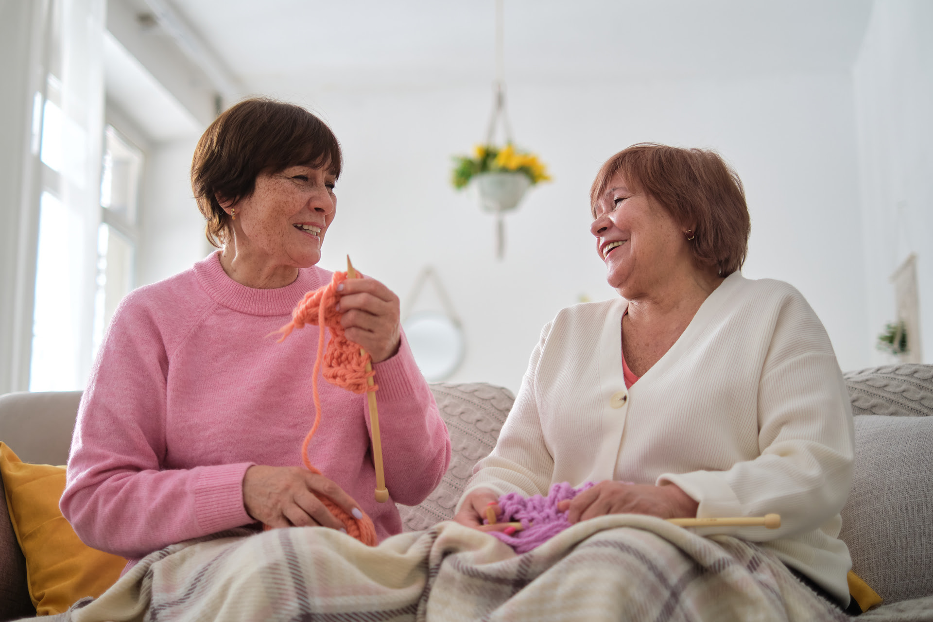 two senior women knitting together